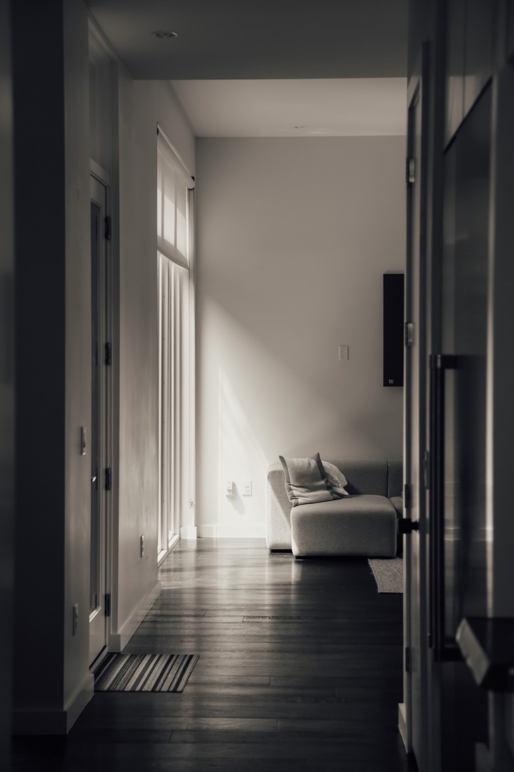 Hol în lumină laterală, cu o canapea la capăt, fotografie alb-negru